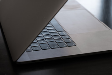 Grey modern laptop on a black table, beautiful light.