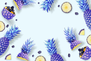 Frame made of pineapple and berries. Bright neon trendy background. Flat lay, top view, copy space....
