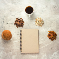 Notebook, pencil, Biscuits, Oatmeal, Coffee, raisins and a cup of coffee. Breakfast Concept
