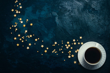 Cup of coffee and stars on a dark blue background. Concept of the Starry sky and Coffee. Flat lay, top view