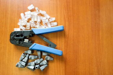 set of telecommunication network tools ( Crimp Crimper and RJ45 connectors) on wooden table background
