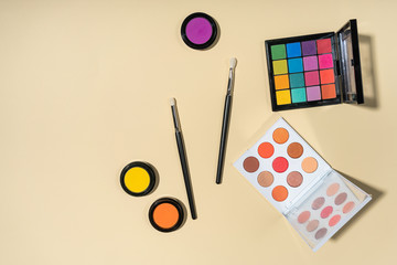 Set of brushes and eyeshadows on a yellow background