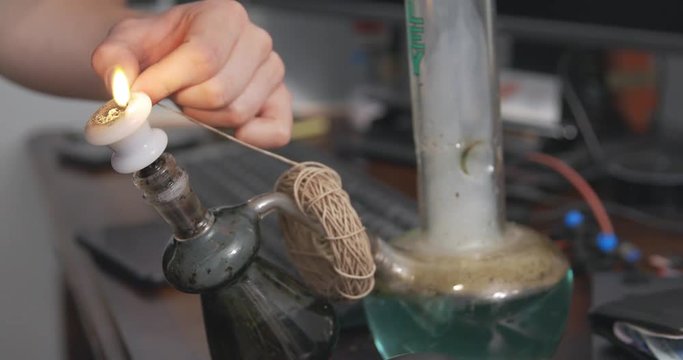 Hemp wick around the base of a bong is lit and used to light a bowl of cannabis.