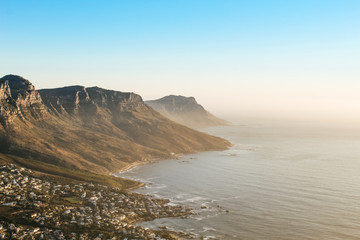 Fototapeta na wymiar View of the 12 apostles and Camps Bay seen from the peak of Lions Head lookout point at sunset.
