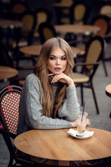 Beautiful young woman in traditional Parisian outdoor cafe