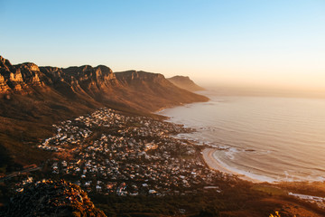 View of the 12 apostles and Camps Bay seen from the peak of Lions Head lookout point at sunset.