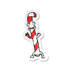 retro distressed sticker of a cartoon dancing christmas candy cane