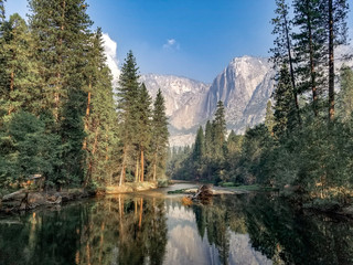 Looking toward Yosemite Falls reflecting off of the Merced River in Yosemite National Park