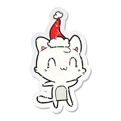 distressed sticker cartoon of a happy cat wearing santa hat