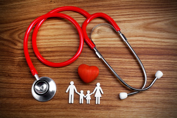 Medical Insurance Concept. Family cutout and Stethoscope on wooden background
