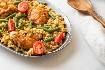 Grilled chicken thighs with bulgur, asparagus beans and tomatoes. Delicious lunch.