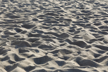 Fototapeta na wymiar A sandy beach with many traces created by people