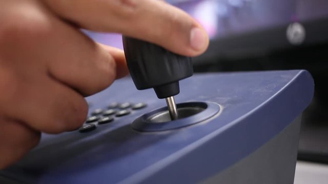 Security guard uses a joystick to control a security camera. Close up of hands