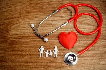 Medical Insurance Concept. Family cutout and Stethoscope on wooden background