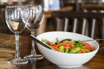 Traditional Mediterranean food. Two glasses and dish with fresh sliced vegetables. on the table in the restaurant.