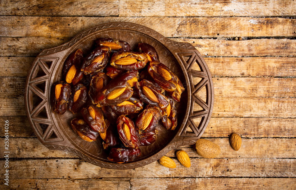 Poster fresh dates with almonds on a table