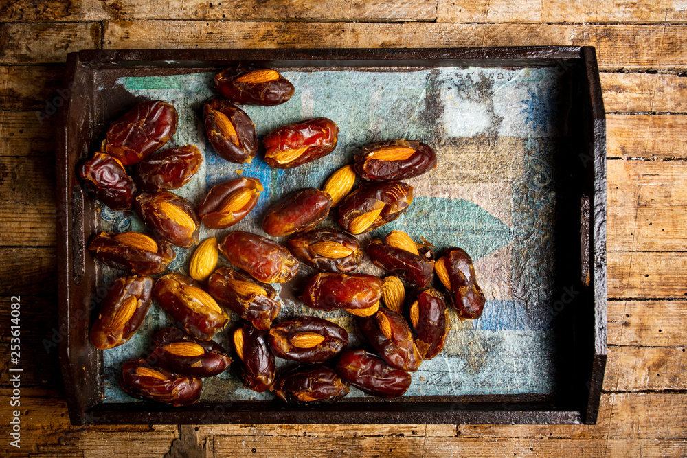 Poster fresh dates with almonds on a table