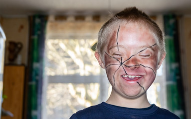 Fototapeta premium Happy boy with down syndrome, prepared and painted for home theater.