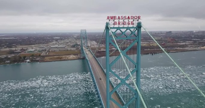 The waterfront of Detroit, Michigan in winter with the Ambassador Bridge in the foreground.