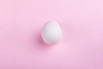 white egg on pastel pink background, concept Happy Easter