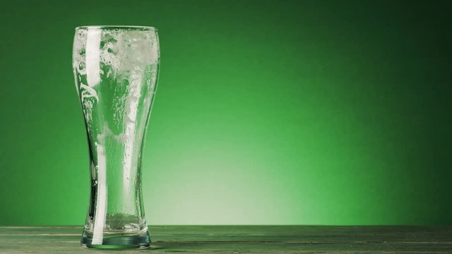 Stop motion animation of a beer being drunk.against a green background with copy space