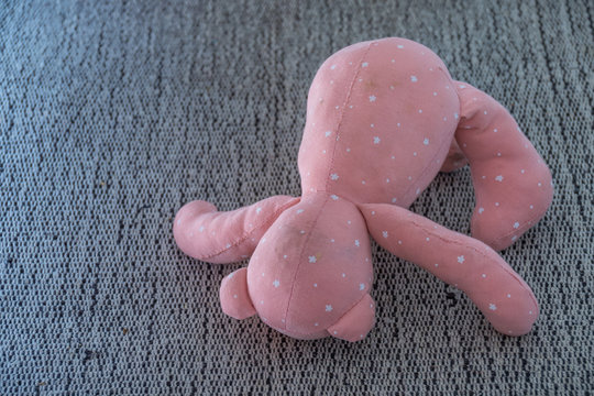 Discarded Child's Pink Soft Toy Isolated On A Grey Carpet Image With Copy Space