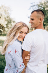 Portrait happy young smiling couple in love over flowering spring garden