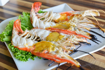 Cutting half grilled giant river prawn, famous local Thai luxury fine dinning menu in Thailand,...