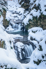 Winter landscape with a waterfall among the rocks.