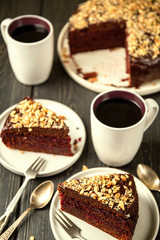 Homemade cake covered with chocolate icing and walnuts cut into slices and tea.High angle shooting, selective focus.