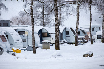 Family holiday in the winter. Winter camping with caravan. Camp site in the snow. Camping and...