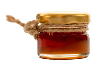 Honey in small jar with jute string decoration, isolated on white background