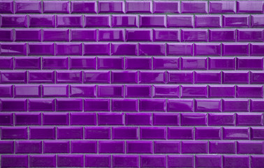 Shiny purple brick tiles on wall. Background texture