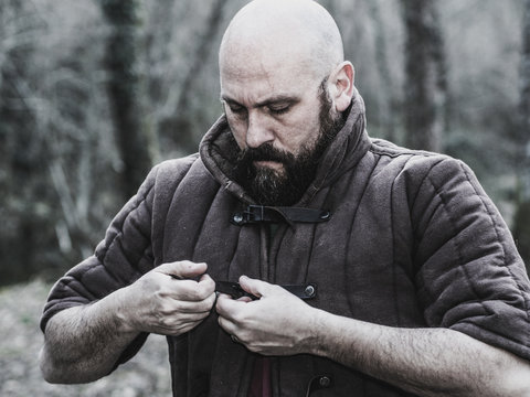 Viking tying his gambeson leather armor