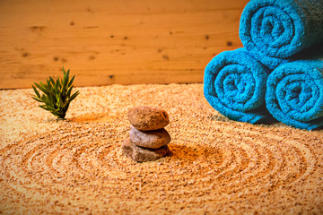 Wellness - Handtücher auf Sand mit Bambus und Steinen