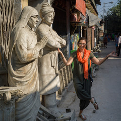 Naklejka premium Woman posing near statues of Mother Teresa and Swami Vivekananda, Kumartuli, Kolkata, West Bengal, India