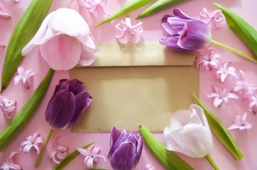 Vintage square card with close up opened craft paper envelope filled with spring blossom purple lilac flowers. Top view, flat lay.