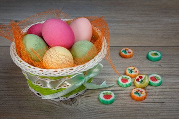 Multi-colored Easter eggs and sweets in a beautiful basket.