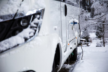 Electricity connection on a rv in the winter time. winter camping in the mountains.  - obrazy, fototapety, plakaty