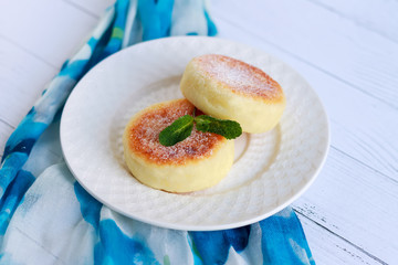Cottage cheese pancakes or curd fritters decorated powdered sugar in plate close view. Healthy and diet breakfast.