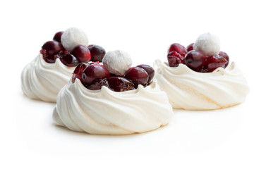 Mini Pavlova meringue nests with fresh and sugared cranberry isolated on white