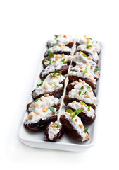Dates stuffed with cream cheese and almonds isolated on white