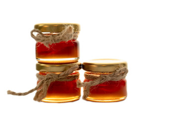 Three tiny jars with honey decorated with jute string, isolated on white background, idea for wedding gift