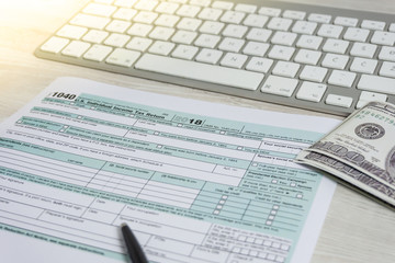 Obraz premium US tax form next to computer keyboard and tax form 1040. tax form us business income office hand fill concept