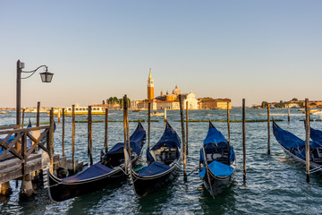 Gondolas moored by Saint Mark square with San Giorgio di Maggiore church in the background in Venice, Italy