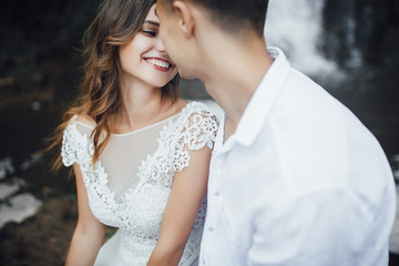 Happy bride and groom on their wedding day on waterfall!