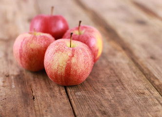 Ripe red apples on rustic wooden table - close up