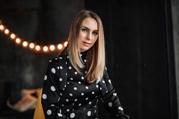 A beautiful girl in a black dress posing at a black barrel.