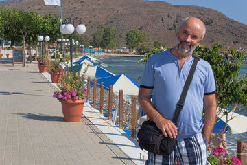 Smiling mature man on the promenade of Georgioupolis