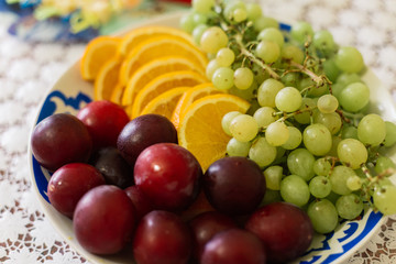 Fresh assorted fruit on a white plate.